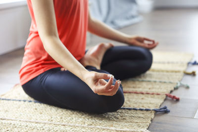 Low section of woman meditation on floor