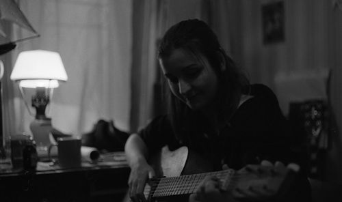 Woman playing guitar at home