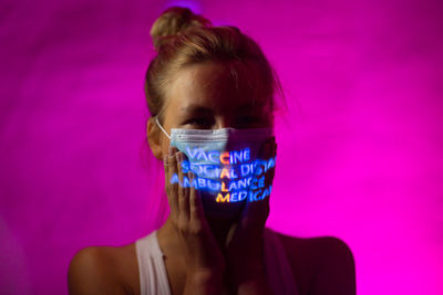 Portrait of woman against pink background