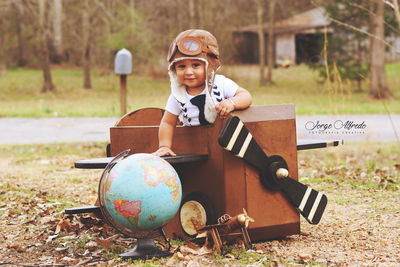 Boy playing with ball sitting on tree