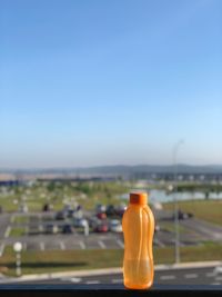 Close-up of bottle on road against clear sky