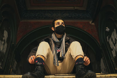 Portrait of man sitting on staircase in building