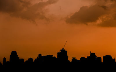 Silhouette buildings against sky during sunset