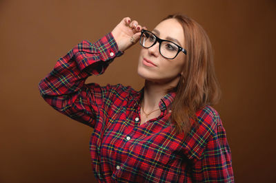 Young woman wearing mask against gray background