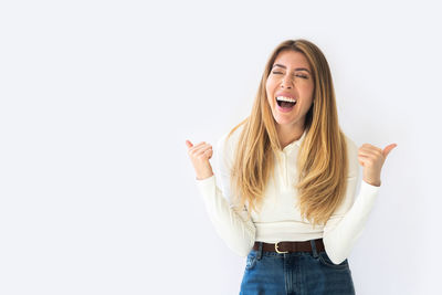 Portrait of young woman standing against white background