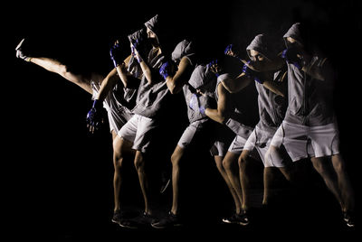 People dancing against black background