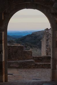 View of old ruin building through arch window