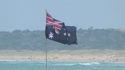 Low angle view of flags against clear sky