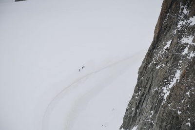 High angle view of people on snowcapped mountain against sky