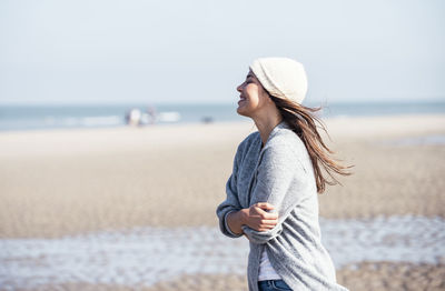 Man wearing hat while standing on beach