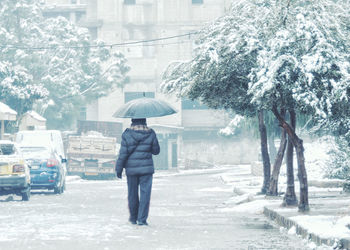 Man standing on street in rain