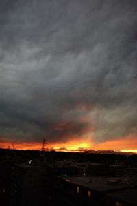 Storm clouds over city during sunset