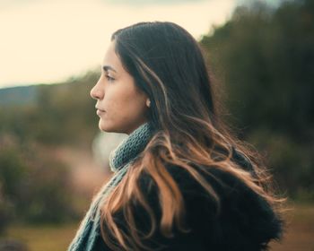 Portrait of young woman looking away outdoors