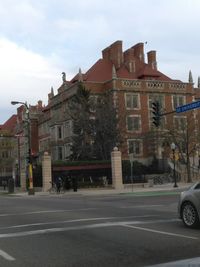 Cars on street in city against sky