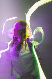 Rear view of woman holding illuminated string lights. longing