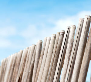 Low angle view of wooden fence against sky