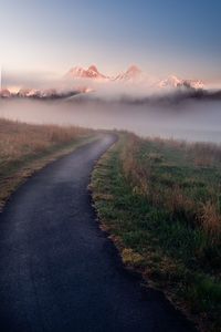 Road by landscape against sky during sunset