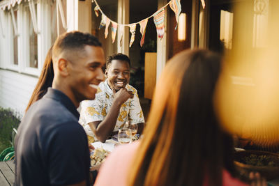 Happy friends enjoying at dinner party in back yard