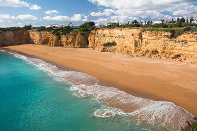 Scenic view of beach against cloudy sky