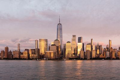 Modern buildings in city against cloudy sky