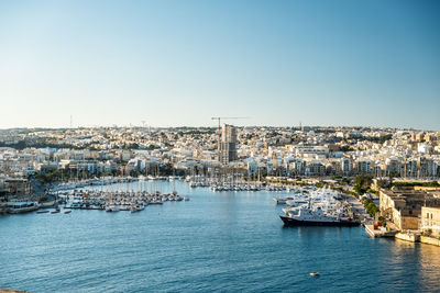 Scenic view of sea and buildings against clear sky