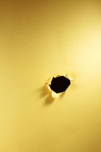 Close-up of yellow hole on wall