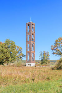 Low angle view of tower on field against clear sky