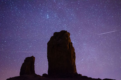 Rock formations against sky at night