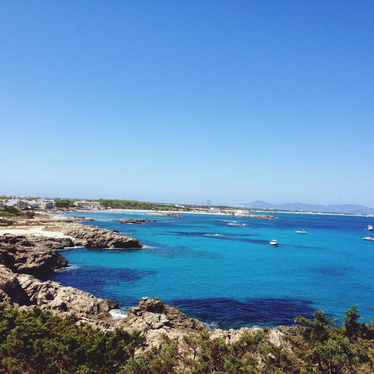 blue, water, clear sky, sea, copy space, tranquil scene, tranquility, scenics, horizon over water, beauty in nature, nautical vessel, nature, transportation, beach, shore, day, idyllic, coastline, rock - object, mode of transport