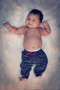 Portrait of cute baby boy on bed