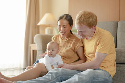 Parents playing with cute son at home