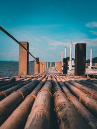 Stack of pipes on sea against sky