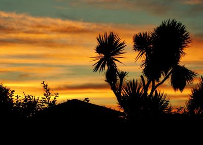 Low angle view of silhouette palm trees against sunset sky