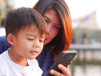 Woman and son looking at mobile phone