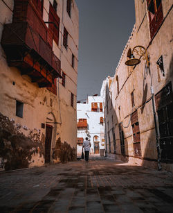 Rear view of people walking on street in city