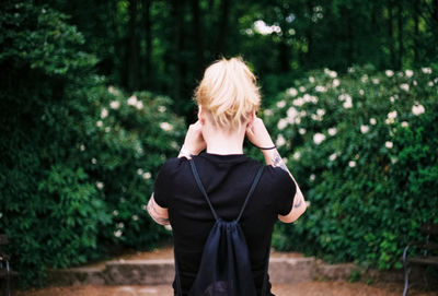 Rear view of woman standing in forest