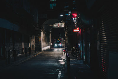 Illuminated street amidst buildings at night