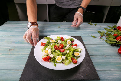 Midsection of man holding salad in plate