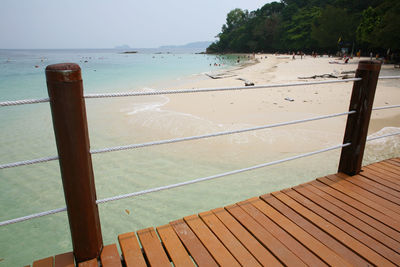 Wooden posts on beach against sky