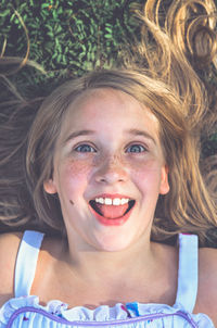 High angle portrait of girl lying down on field