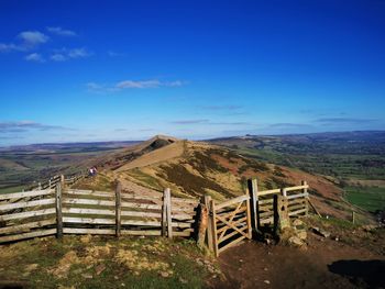 Fence on field against blue sky