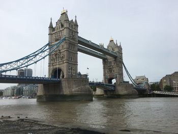 Tower bridge over thames river in city against sky