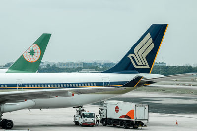 Airplane on airport runway against sky