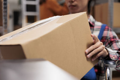 Midsection of woman holding box