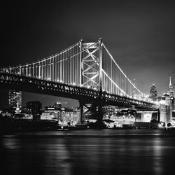 View of suspension bridge in city at night