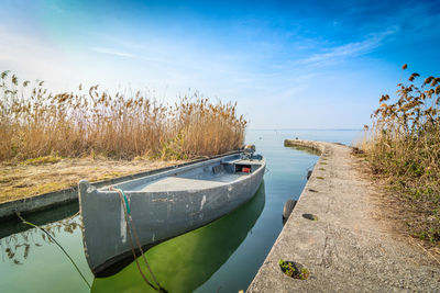 Boats moored on beach against sky