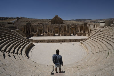 A man standing near the ancient roman theater in jerash, jordan