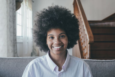 Portrait of smiling woman sitting on sofa at home