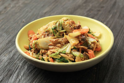 Capcay goreng  on wooden table. chinese food indonesian stir fry vegetable with chicken and seafood