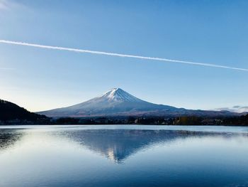 Scenic view of lake and mountains against blue sky